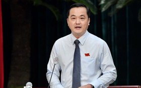 市工商廳廳長裴佐黃宇在會議上回答人民議會代表的質詢。（圖：越勇）