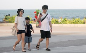 一個三口之家小家庭的韓國遊客在遊逛芽莊海邊風光。（圖：中宇）