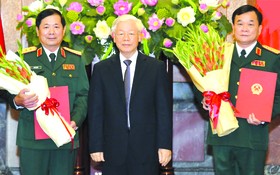 　　總書記、國家主席阮富仲向兩位中將頒授晉升《決定》。