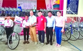 　　溫陵會館理事與第五郡紅十字會代表贈送 自行車給貧困學生。