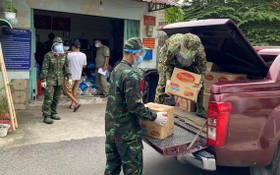 部隊力量把準備供應給民眾的食品、蔬菜裝上車。