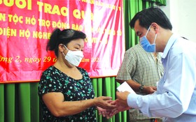 市民族處副主任曾福祿向感染新冠肺炎病 毒的華人同胞贈送資助金。