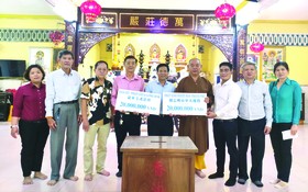 　　阮玉英主編(右五)接受市華人佛教、 龍華寺護法會贊助贈報經費。
