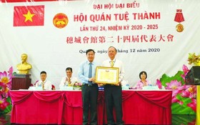 第五郡越南祖國陣線委員會主席向穗城會館理事長盧耀南頒發獎狀。