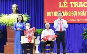 市人民議會主席阮氏麗向黨員頒授黨齡紀念章。