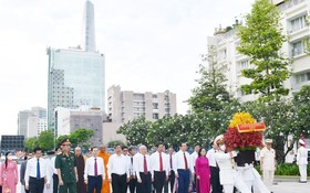 市領導代表團在第一郡阮惠街胡志明主席塑像公園敬獻花籃。