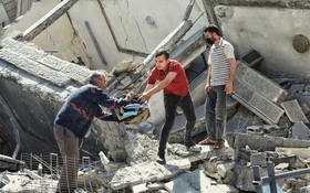 以色列發動襲擊後，人們從加沙的一座受損建築中搶救財產。