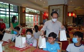 越南時代廣場投資股份 公司總經理張豐裕先生和 女兒向清寒學生贈送禮物。