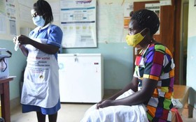 在烏干達卡巴萊的一家醫療中心，一名護士準備為一名患者接種新冠疫苗。