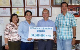 穗城會館理事長盧耀南(右二)和副理事長 林海泉(右一)向本報領導移交5000萬元贈款。
