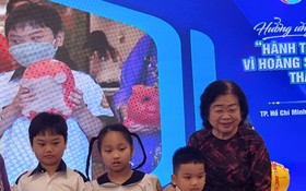 原國家副主席張美華(右一)接收小學生捐贈“土豬”。
