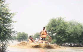 在巴基斯坦拉金布林，救援人員幫助受災民眾撤離。