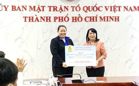 市越南祖國陣線委員會主席陳金燕接受捐款。