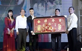 張滿燕（左一）與長子江建昌(左三)接受六桂堂 宗祠贈送祝賀金牌後，並向該宗祠捐款。