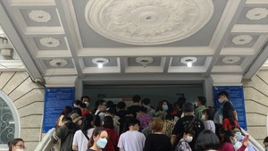 People in HCMC wait in long queues at passport office on July 1