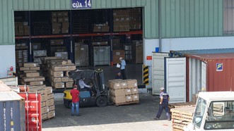 Hàng hóa tại kho vận Tân Cảng - Cát Lái đang được vận chuyển xuất nhập vào các container. Ảnh: HOÀNG HÙNG
