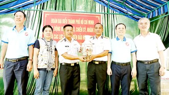 Phó Bí thư Thành ủy TPHCM Nguyễn Văn Hiếu cùng các đại biểu tặng quà cho Trạm radar 595. Ảnh: NGÔ BÌNH