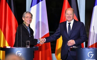 德國總理朔爾茨（右）同法國總理博爾內在新聞發佈會上握手。（圖：新華社）