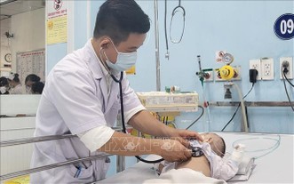 市第一兒童醫院感染神經科主任余俊歸醫生在為一名腦膜炎病童查體。（圖：越通社）