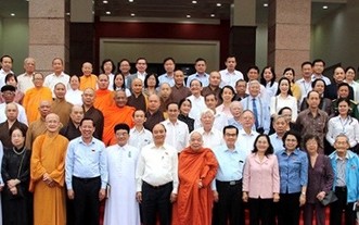 國家主席阮春福（前排左五）和市領導與諸位具威信華人同胞、 各宗教代表等合照留念。（資料圖）