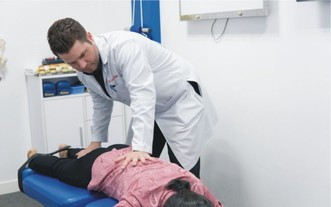 Luke Hamman醫生正在為病人檢查脊柱。