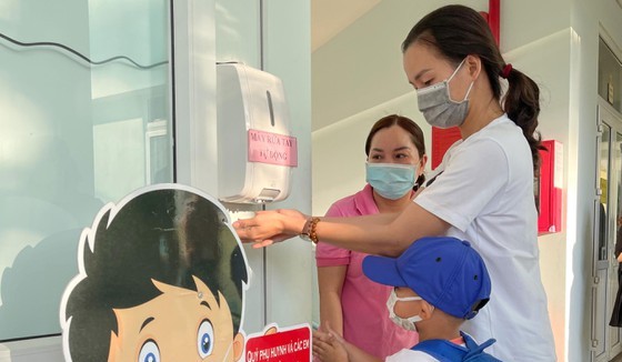 Các bé Trường Mầm non Tuổi Thơ (quận 8) được hướng dẫn vệ sinh, khử khuẩn trước khi vào lớp. Ảnh: HOÀNG HÙNG
