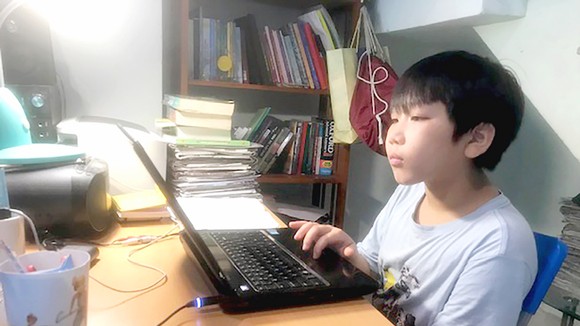 Học sinh tham gia một tiết học online tại nhà. Ảnh: NGUYỄN HÒA