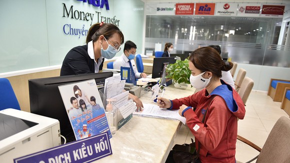 Nhận kiều hối tại một ngân hàng trên đường Nguyễn Thị Minh Khai, Q.3, TP.HCM - Ảnh: NGỌC PHƯỢNG