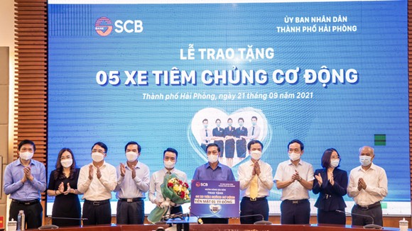 Đại diện SCB trao bảng tượng trưng tặng 05 chiếc xe tiêm chủng cơ động