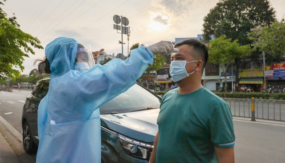 Kiểm tra thân nhiệt cho tài xế lái xe vào TPHCM. Ảnh: HOÀNG HÙNG