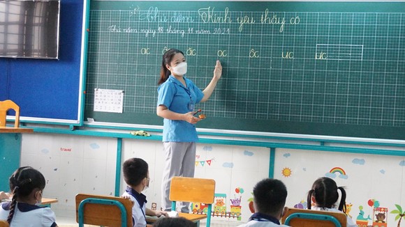 Cô Đỗ Trần Thanh Thi và học sinh lớp 1.1 Trường tiểu học Thạnh An, huyện Cần Giờ (TPHCM) trở lại trường học từ ngày 20-10. Ảnh: HOÀNG HÙNG