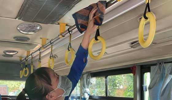 A worker is cleaning and disinfecting a bus. (Photo: SGGP)
