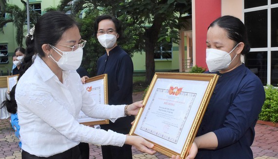 Vice Chairwoman of the HCMC Chapter of the Vietnam Fatherland Front Phan Kieu Thanh Huong presents certificates of merit to religious volunteers. (Photo: SGGP)