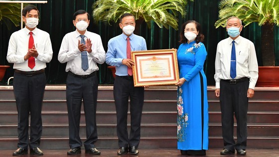 Chairwoman of the HCMC People’s Council, Nguyen Thi Le hands over the Certificate of Merit from the Prime Minister to the HCMC Party Committee's Commission for Mass Mobilization.