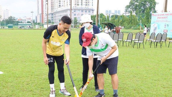 Huấn luyện viên hướng dẫn các kỹ thuật cơ bản trong bộ môn hockey cho các trẻ đặc biệt và phụ huynh. Ảnh: NGUYỄN ANH