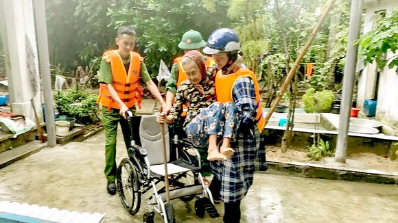 Lực lượng vũ trang tỉnh Quảng Nam hỗ trợ người già yếu đến nơi an toàn. Ảnh:  MINH HUY