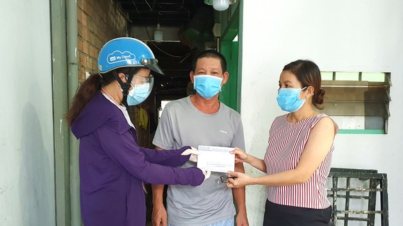 Đại diện chương trình “Một gia đình trợ giúp một gia đình”  trao hỗ trợ gia đình anh Lê Văn Còn (phường 28, quận Bình Thạnh)