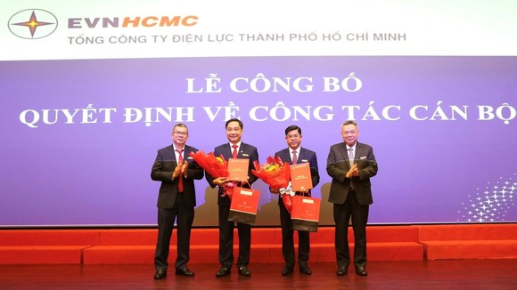Ông Bùi Hải Thành và ông Nguyễn Thanh Nhã nhận quyết định và hoa chúc mừng từ Chủ tịch EVNHCMC Phạm Quốc Bảo (bìa phải) và Tổng Giám đốc EVNHCMC Nguyễn Văn Thanh (bìa trái)