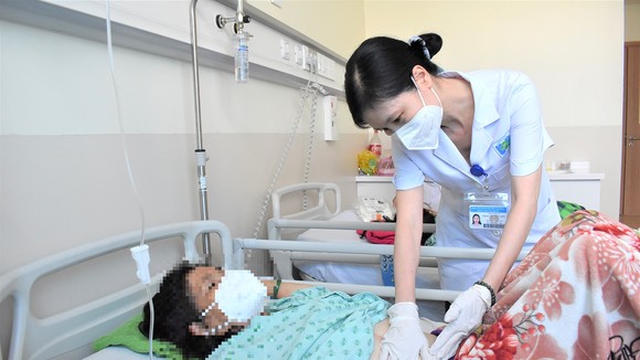 TS-BS Phan Thị Hồng Đức, Trưởng khoa Nội tuyến vú, tiêu hóa, gan, niệu, BV Ung bướu TPHCM thăm khám bệnh nhân tại khoa Nội 4