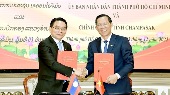 Trao đổi Bản ghi nhớ hợp tác giữa UBND TPHCM và chính quyền tỉnh Champasak. Ảnh: VIỆT DŨNG