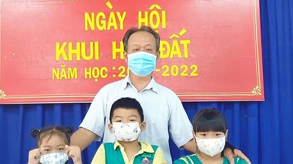 Thầy Nguyễn Phúc Hiếu và học sinh Trường Mầm non An Phú trong Ngày hội Khui heo đất