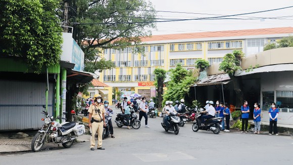 Lực lượng CSGT TPHCM cùng Đội CSGT-TT Công an quận 3 túc trực tại điểm thi trường THCS Colette đường Hồ Xuân Hương, phường 6, quận 3. Ảnh: CHÍ THẠCH