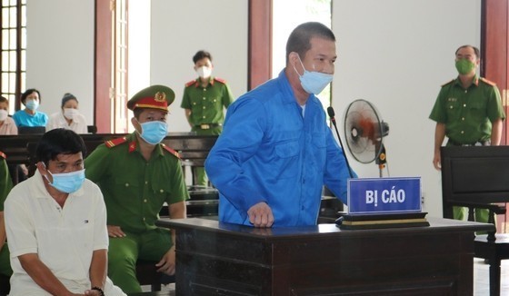 Bị cáo Phạm Văn Cung (áo xanh) và bị cáo Nguyễn Tuấn Sĩ tại phiên xét xử sơ thẩm. Ảnh: QUỐC AN