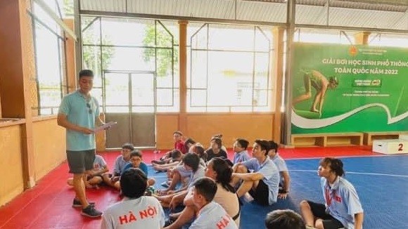 HLV Đỗ Huy Long trao đổi cùng các học viên nhí của mình tại giải bơi học sinh phổ thông toàn quốc 2022 vừa qua. Ảnh: FTSM