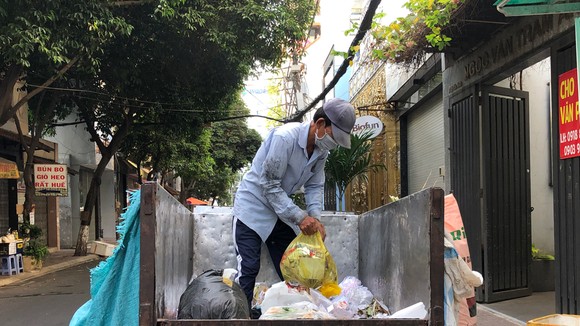 Công nhân thu gom rác vẫn cho tất cả rác thải vào chung xe ba gác để chở đến điểm tập kết
