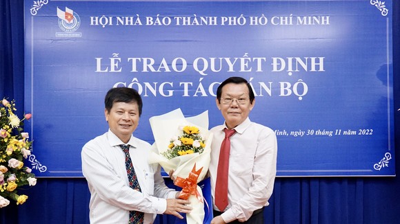 Nhà báo Trần Trọng Dũng trao hoa và quyết định cho nhà báo Nguyễn Tấn Phong. Ảnh: HOÀNG HÙNG