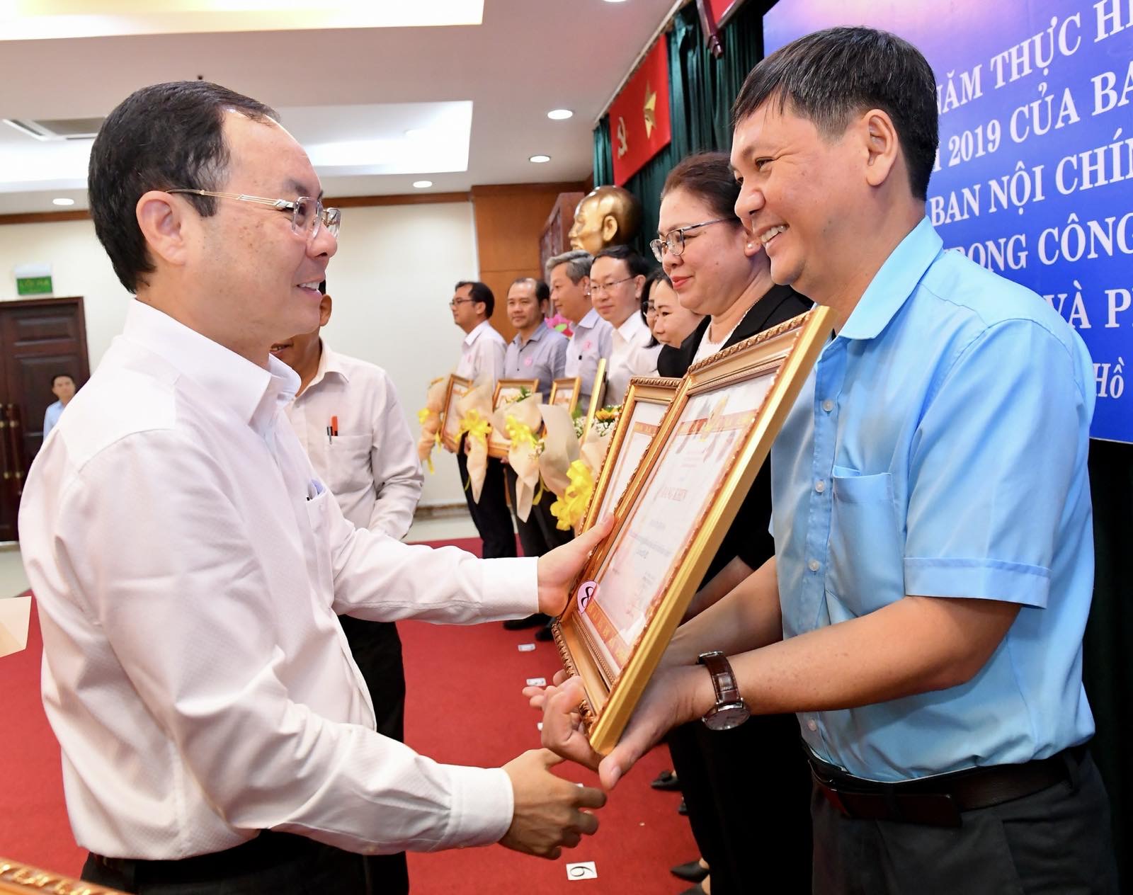 Phó Bí thư Thành ủy TPHCM Nguyễn Văn Hiếu trao bằng khen cho các tập thể. Ảnh: VIỆT DŨNG