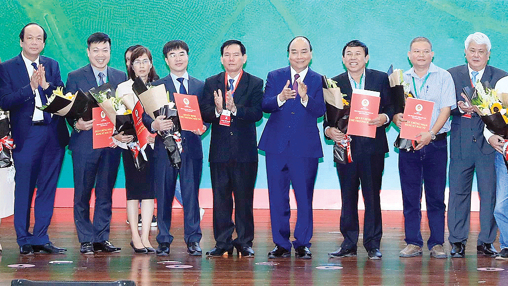 Thủ tướng Nguyễn Xuân Phúc chứng kiến các doanh nghiệp nhận quyết định  chủ trương đầu tư, ghi nhớ đầu tư vào tỉnh Trà Vinh. Ảnh: TTXVN