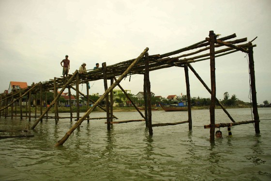Người dân Quảng Ngãi dầm nước sông bắc cầu gỗ đón Tết ảnh 1