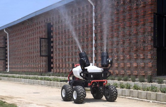 Một robot đang phun khử khuẩn bên ngoài một trang trại lợn ở Giang Tây - Ảnh: Getty/Bloomberg.